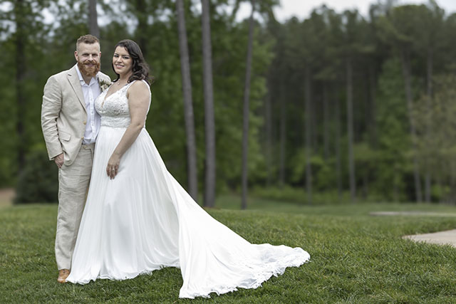 Wedding portrait of a couple together in a grassy outdoor setting